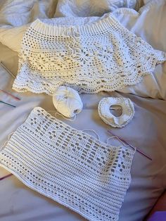 crocheted items are laid out on a bed