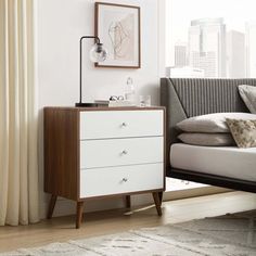 a white bed sitting next to a window in a bedroom