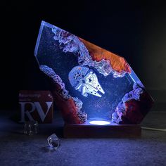 an illuminated rock with a star wars scene on it and a ring in the foreground