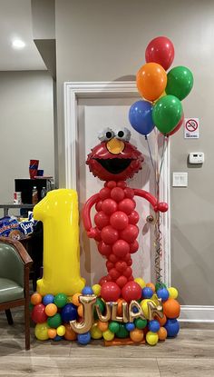 the balloon man is standing in front of his first birthday