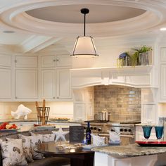 a large kitchen with white cabinets and an island in front of the stove top oven