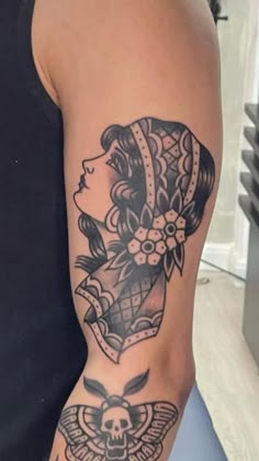 a woman's arm with a tattoo on it and a skull in the middle