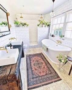 a bathroom with two sinks and a bathtub in the middle, along with a rug on the floor