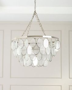 a chandelier hanging from a ceiling in a room with white paneled walls