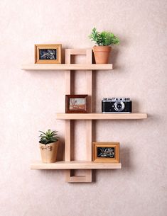 three wooden shelves with plants and pictures on them