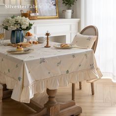 a dining room table covered with a white table cloth and place setting for two people