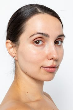 a close up of a woman's face with no shirt on and brown eyes