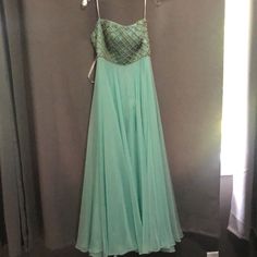 This Is A Strapless Sherri Hill Pageant Dress That Is A Size 00. It Has The Bra Cups Sewn In. It Is A Mint Green Color With Gorgeous Crisscross Rhinestones Across The Bodice. It Was Worn Once And Does Have A Few Stains On The Outside Layer Of Tulle. These Stains May Come Out With Hand Washing The Few Areas. It Is Gorgeous And Still Has Plenty Of Pageant Life In It. Green Evening Dress With Sheer Bodice, Green Evening Dress With Sweetheart Neckline, Green Dresses With Sweetheart Neckline And Lined Bodice, Green Strapless Dress With Sweetheart Neckline For Gala, Elegant Green Gown With Sheer Bodice, Green Sweetheart Neckline Evening Dress, Green Gala Gown With Lined Bodice, Green Floor-length Evening Dress With Lined Bodice, Green Evening Dress With Sweetheart Neckline And Pleated Bodice