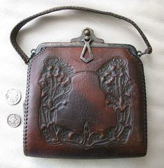 a brown leather purse sitting on top of a white blanket