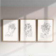 three black and white art prints hanging on the wall above a vase filled with flowers