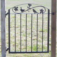 an iron gate with flowers and birds on it