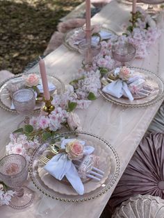 the table is set with pink flowers and silverware for an elegant dinnereonal