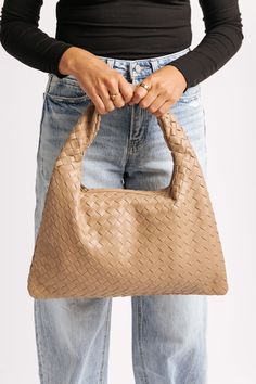 The Leah Natural Woven Vegan Leather Shoulder Bag combines style and functionality with its slouchy shape and beautiful woven design! Crafted from vegan leather, this shoulder bag features a secure zip closure, complemented by gold hardware for a touch of sophistication. Inside, the fabric-lined interior includes a zip pocket and a slip pocket, perfect for keeping your essentials organized. Its natural hue and relaxed silhouette make it a versatile accessory, ideal for both casual outings and more polished looks. Chic Woven Leather Hobo Bag For On-the-go, Everyday Woven Leather Shoulder Bag For Fall, Everyday Fall Woven Leather Shoulder Bag, Chic Woven Leather Hobo Bag, Trendy Woven Leather Hobo Satchel Bag, Trendy Woven Leather Satchel Hobo Bag, Trendy Woven Leather Crossbody Hobo Bag, Chic Hobo Bag With Braided Double Handles, Chic Travel Hobo Bag With Intrecciato Weave