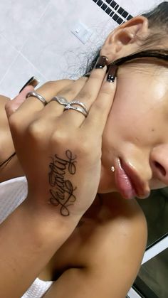 a woman with her hand on her face and the word smile written in cursive writing