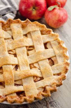 an old fashioned apple pie on a wooden table with apples in the background and text overlay that reads old fashioned apple pie