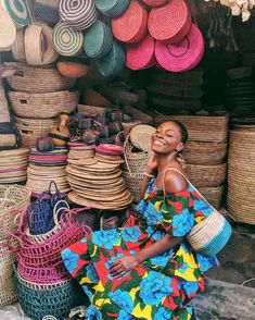 a woman sitting on the ground in front of baskets