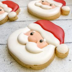 three decorated cookies with santa claus faces on them