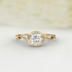 a yellow gold engagement ring with a round diamond in the center and two small diamonds on each side