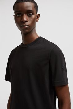 Presented in organic cotton jersey, this streamlined t-shirt is a Moncler classic. A silicone logo patch adorns the sleeve, while a discrete logo is printed on the back. Classic Short Sleeve T-shirt With Logo Patch, Classic Black Top With Logo Patch, Classic Cotton T-shirt With Logo Patch, Casual Tops With Logo Patch And Relaxed Fit, Casual Relaxed Fit Top With Logo Patch, Classic Crew Neck Top With Logo Patch, Personalized Jacket, Outdoor Trekking, Father's Day Specials