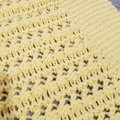 a yellow crocheted blanket laying on top of a table