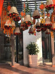 several hanging baskets with flowers on them in front of a building