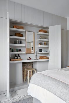 a bedroom with white walls and open shelving