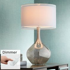 a lamp that is sitting on top of a table next to a remote control and other items