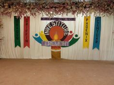 the stage is decorated with colorful banners and flowers on it for an event or celebration