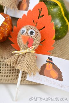 a paper turkey sitting on top of a wooden stick