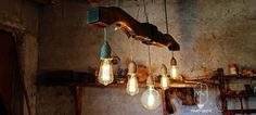 several light bulbs hanging from a wooden beam