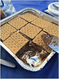 a pan filled with crackers and ice cream on top of a blue table cloth