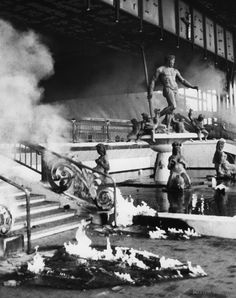 an old black and white photo of people standing on top of firetrucks