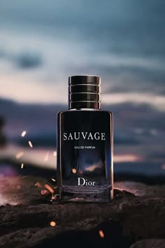 a bottle of dior sauvage sitting on top of a pile of rocks