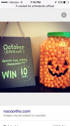 a jar filled with candy sitting on top of a table next to a chalk board