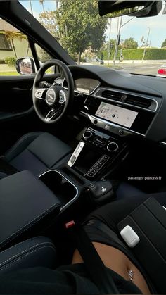 the interior of a modern car with black leather seats and dashboard, along with electronic controls