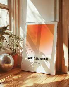 an advertisement for golden hour sits on the floor next to a potted plant