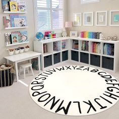 a room with bookshelves, desks and various children's artwork on the wall