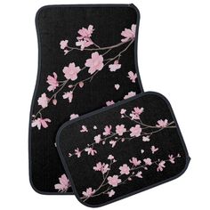 two car mats with pink flowers on black background, one is in the shape of a flower