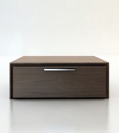 a wooden box sitting on top of a white table next to a black drawer with silver handles