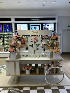 a display in a store filled with lots of flowers and bottles on top of a table