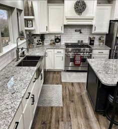 a kitchen with white cabinets and granite counter tops