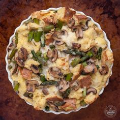 an overhead view of a pie with mushrooms and asparagus in it on a table