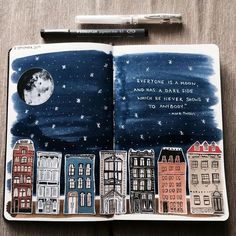 an open notebook with a drawing of buildings and the words everyone is a moon and has a dark side written on it