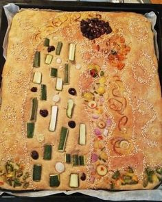 an art work made out of vegetables and other items on a baking sheet in the shape of a tree