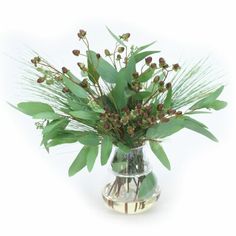 a vase filled with lots of green leaves and flowers