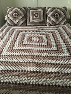 a crocheted bedspread with brown and white squares