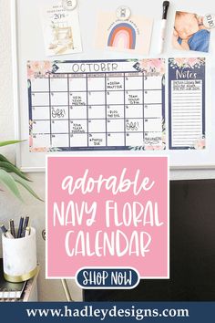 an adorable navy floral calendar is displayed on the wall next to a potted plant