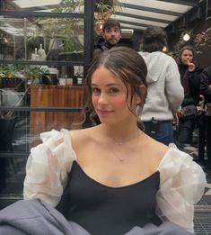 a woman in a black dress sitting at a table