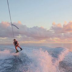 a person on a surfboard riding the waves in the ocean at sunset or dawn