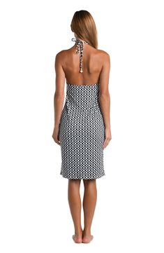 This cover up dress showcases a geometric black and white print, featuring a repetitive, interlocking pattern that gives a sense of intricate tessellation. The high-contrast design creates a striking optical effect, which is both modern and timeless. It features a halter neck style with a sleek, body-hugging silhouette and a knee-length hem, creating an elegant and sophisticated look. [split] Details V-neck midi dress Bra cups Side slits Adjustable neck tie Gold charms Wear solo or as a cover-up Black Beach Dress With Geometric Pattern, Black Geometric Pattern Beach Dress, Black Vacation Dress With Geometric Pattern, Black Dress With Geometric Pattern For Vacation, White Geometric Pattern Dress For Vacation, Interlocking Pattern, Geometric Black And White, Contrast Design, Swimsuit Material